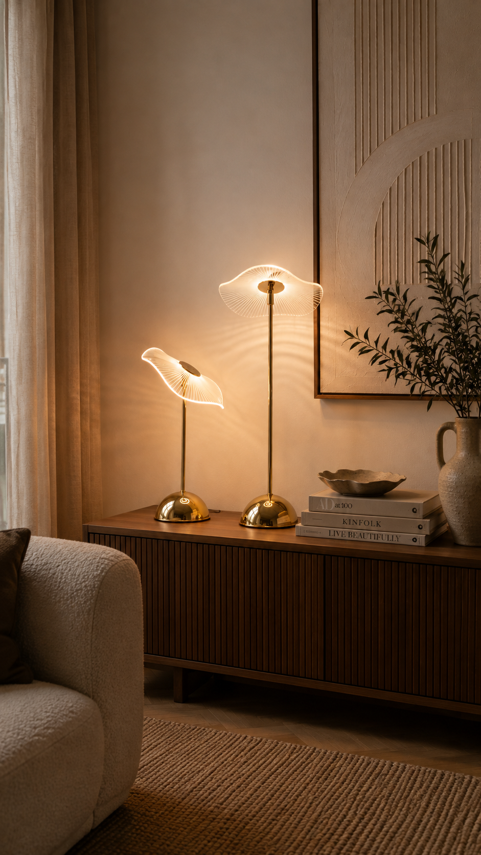 Lampe à poser nomade moderne avec pied cylindrique noir et abat-jour dôme blanc, allumée sur une surface en marbre. Bouton variateur tactile doré visible sur la base. Blomstra Home