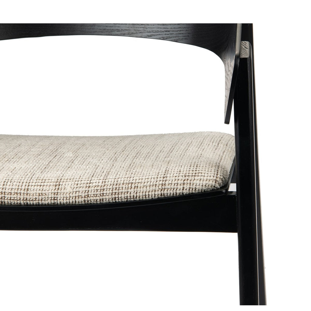 Contraste entre le bois de frêne teinté noir et le tissu texturé beige de l'assise.