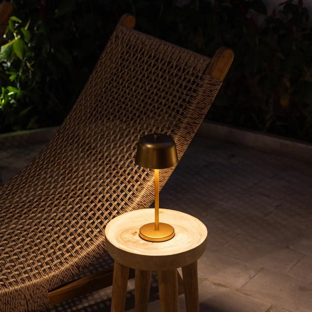 Lampe sans fil allumée sur une terrasse la nuit, ambiance chaleureuse résistante IP54.