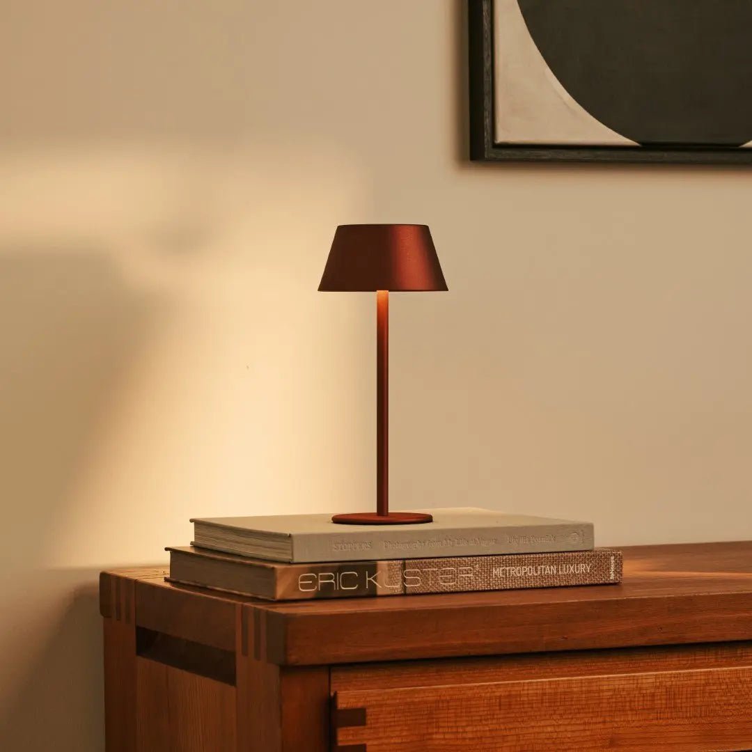 Lampe d'ambiance bronze posée sur des livres, posé sur un meuble