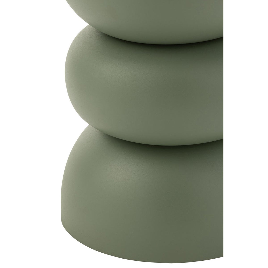 Table d'appoint design en métal vert sauge mat, avec une forme sculpturale rappelant des galets empilés.