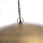 Détail de la chaîne de suspension et de la courbe douce de l'abat-jour en métal.