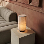 Mise en scène de la lampe Sakura sur un bout de canapé moderne, créant une ambiance tamisée.