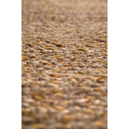 Gros plan sur la texture tressée du grand tapis Elliot en fibres naturelles.