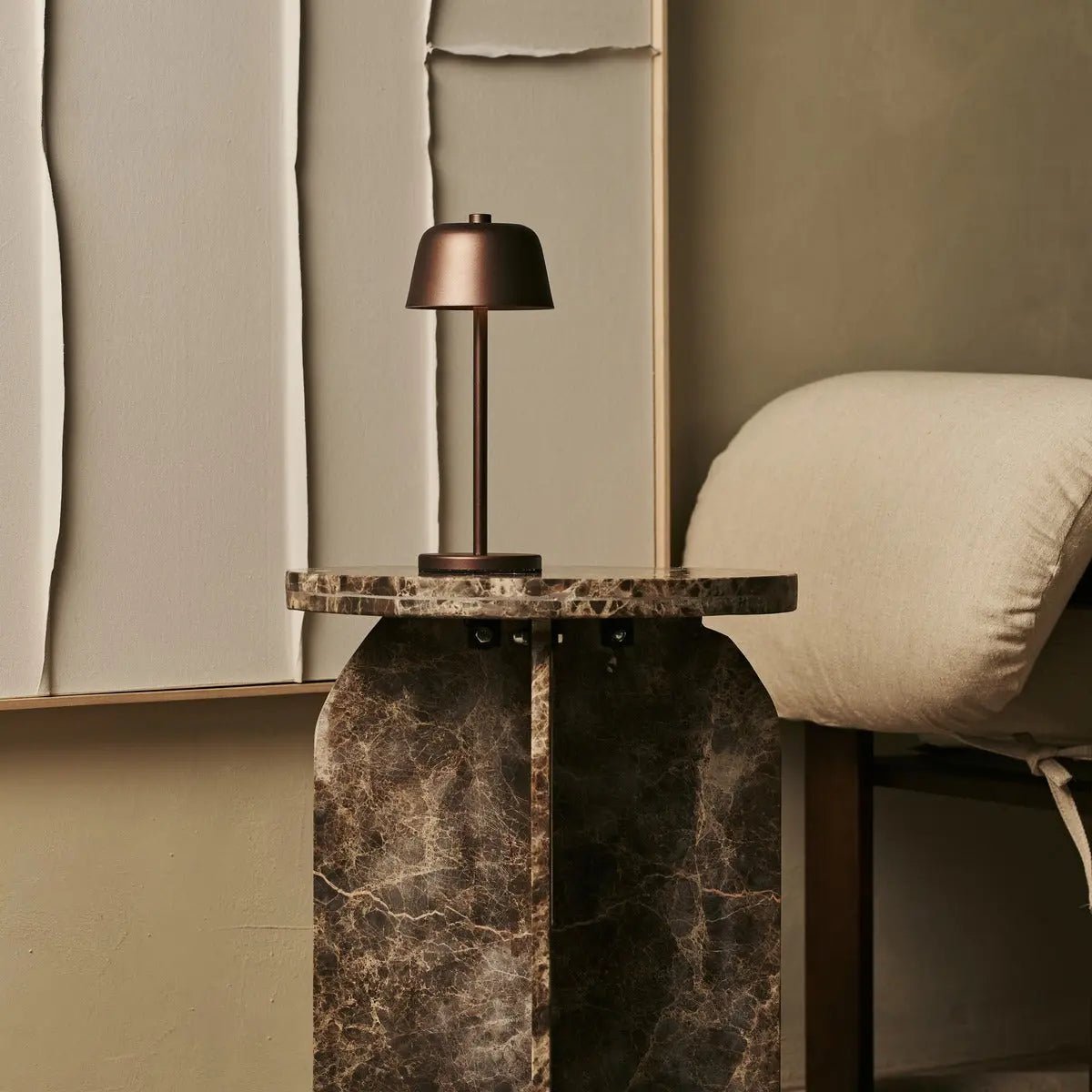 Lampe nomade Anton marron bronze sur un guéridon en marbre sombre, design chic.