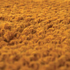 Zoom sur la texture des fibres de jute naturelles teintées en jaune moutarde chaud.
