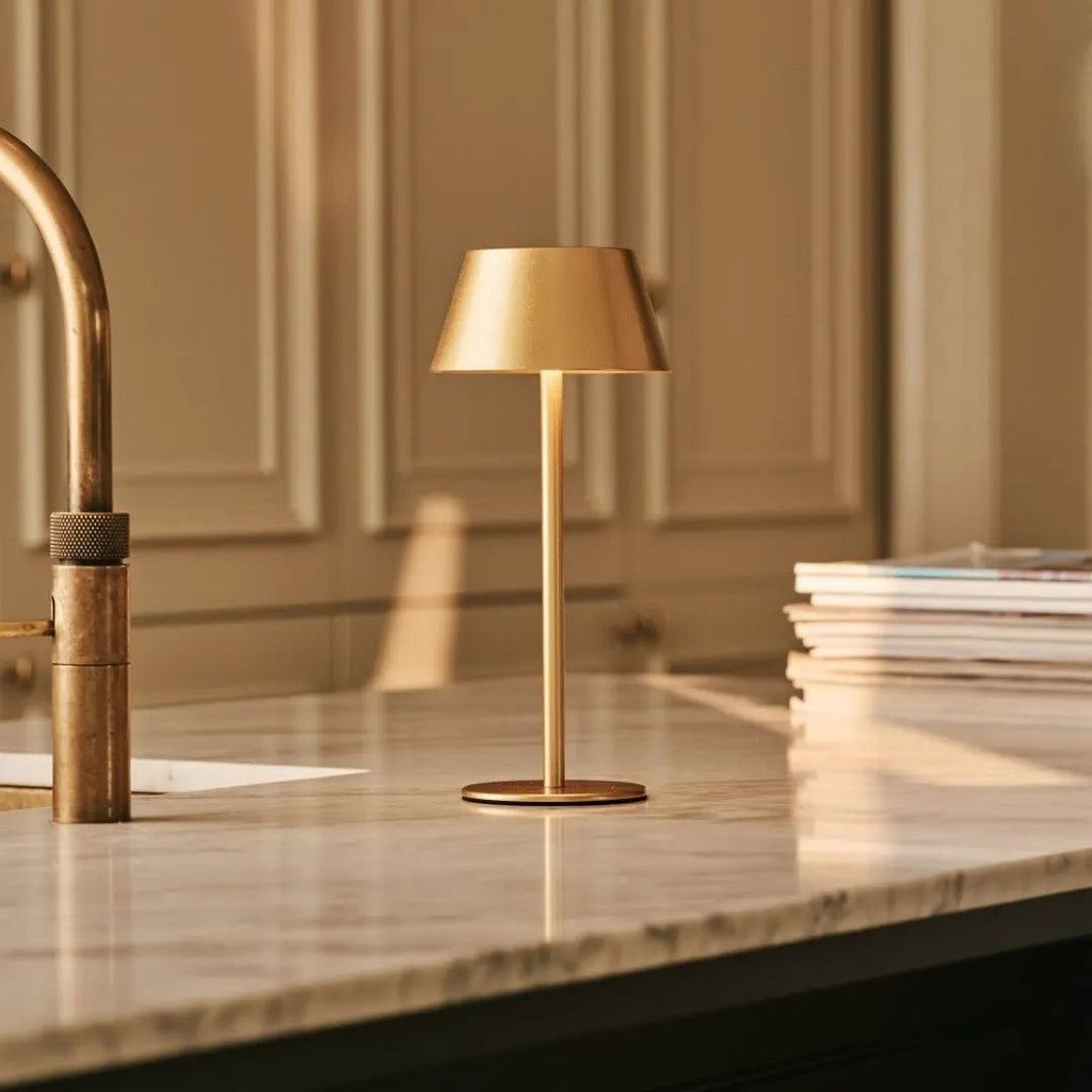 Lampe design or sur un plan de travail de cuisine moderne.