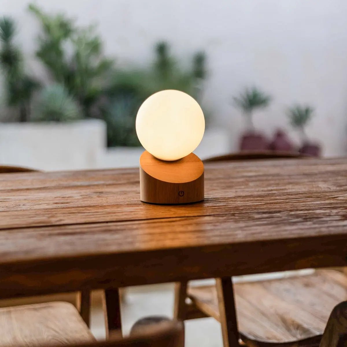 Lampe à poser nomade et sans fil, avec son globe en verre dépoli lumineux et son élégant socle en bois clair.