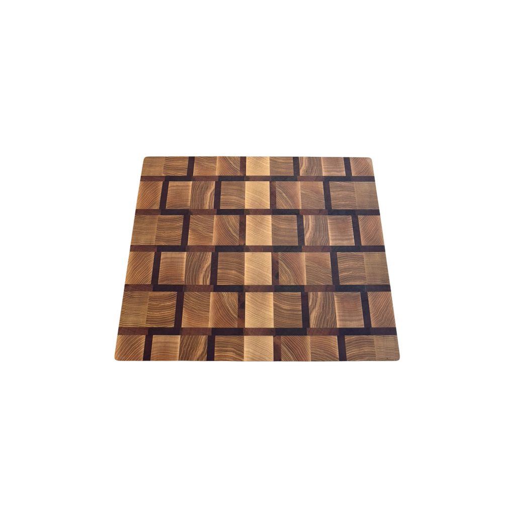 Planche à découper bois de bout motif briques rectangles horizontaux décalés, frêne ambré beige doré joints sapelli brun prune, vue trois-quarts fond blanc, taille moyenne, épaisseur et tranche bois de bout visible