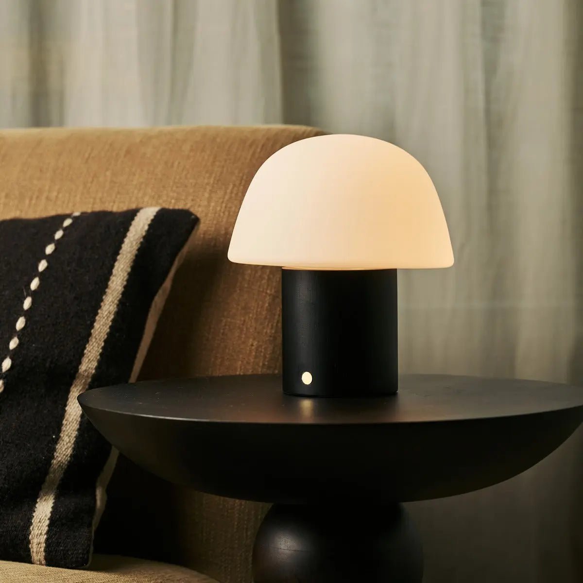 Lampe design sans fil posée sur une table basse dans un salon moderne.
