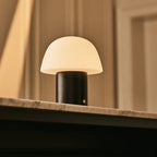 Utilisation de la fonction tactile sur le socle en bois de la lampe nomade Yannick.