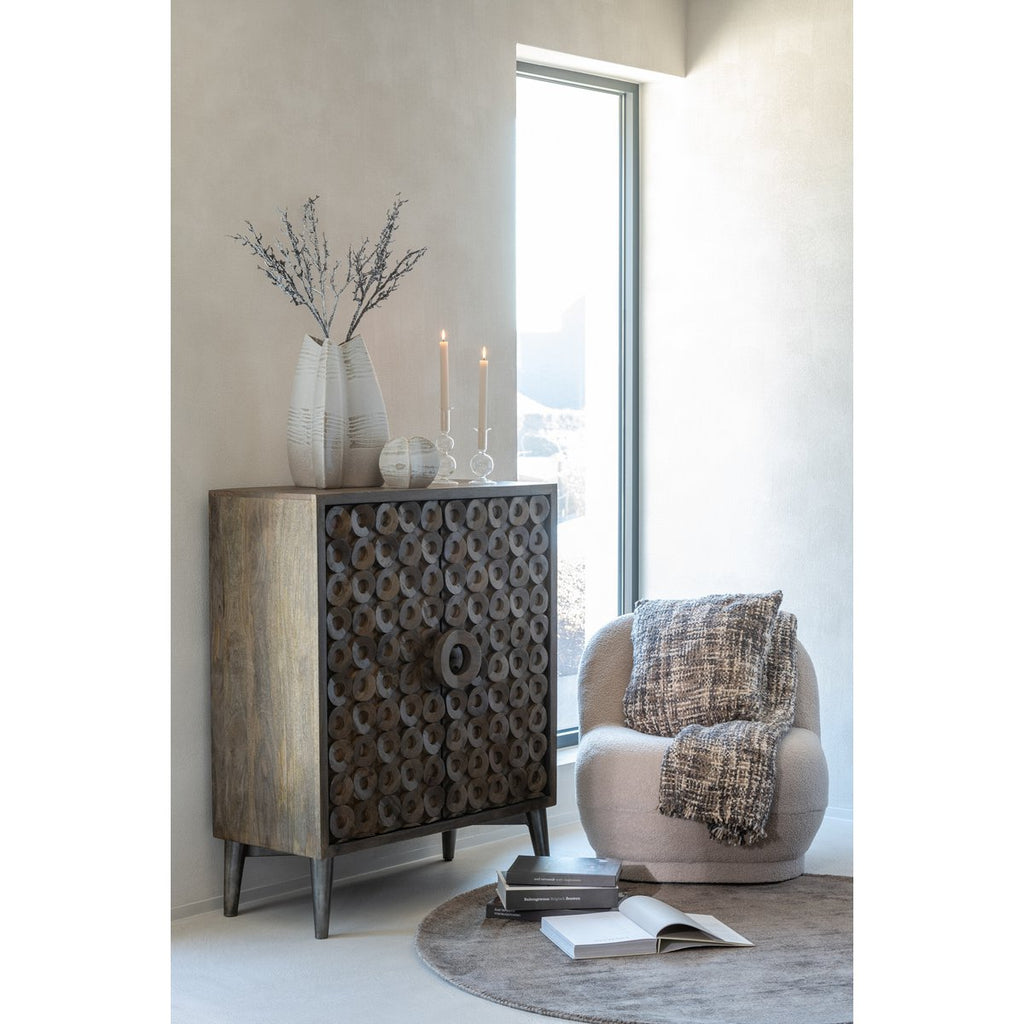 Décoration salon cosy avec coussin tweed marron posé sur un fauteuil près d'une fenêtre