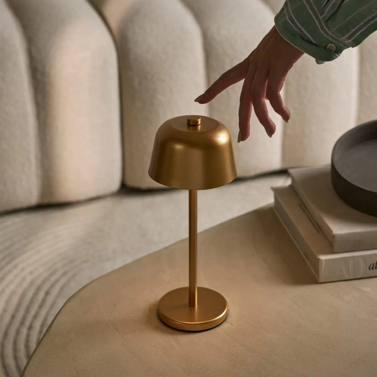 Main effleurant le dessus de la lampe pour régler l'intensité lumineuse (dimmable).