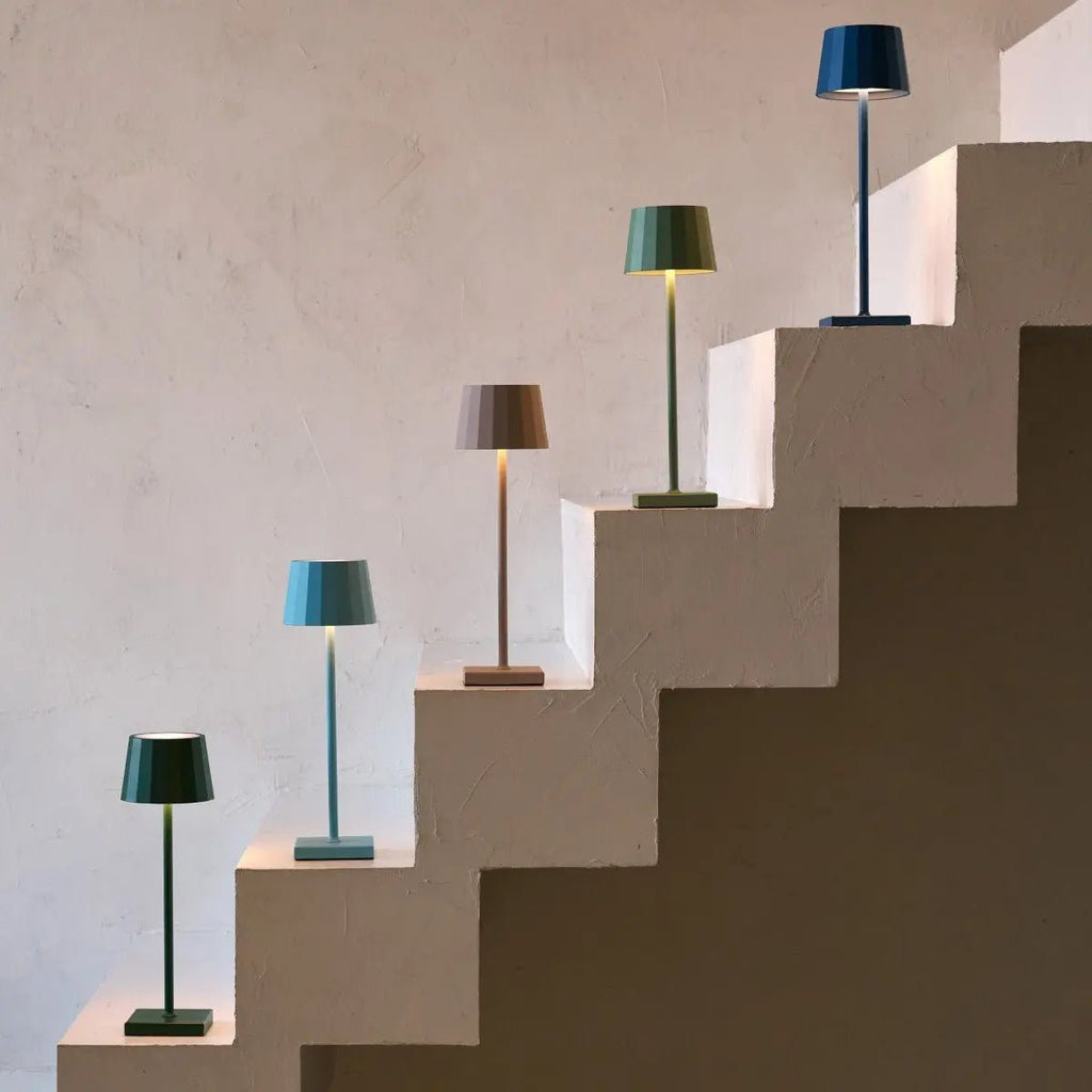 Collection de lampes nomades Tavellio Wouter de différentes couleurs présentées sur un escalier