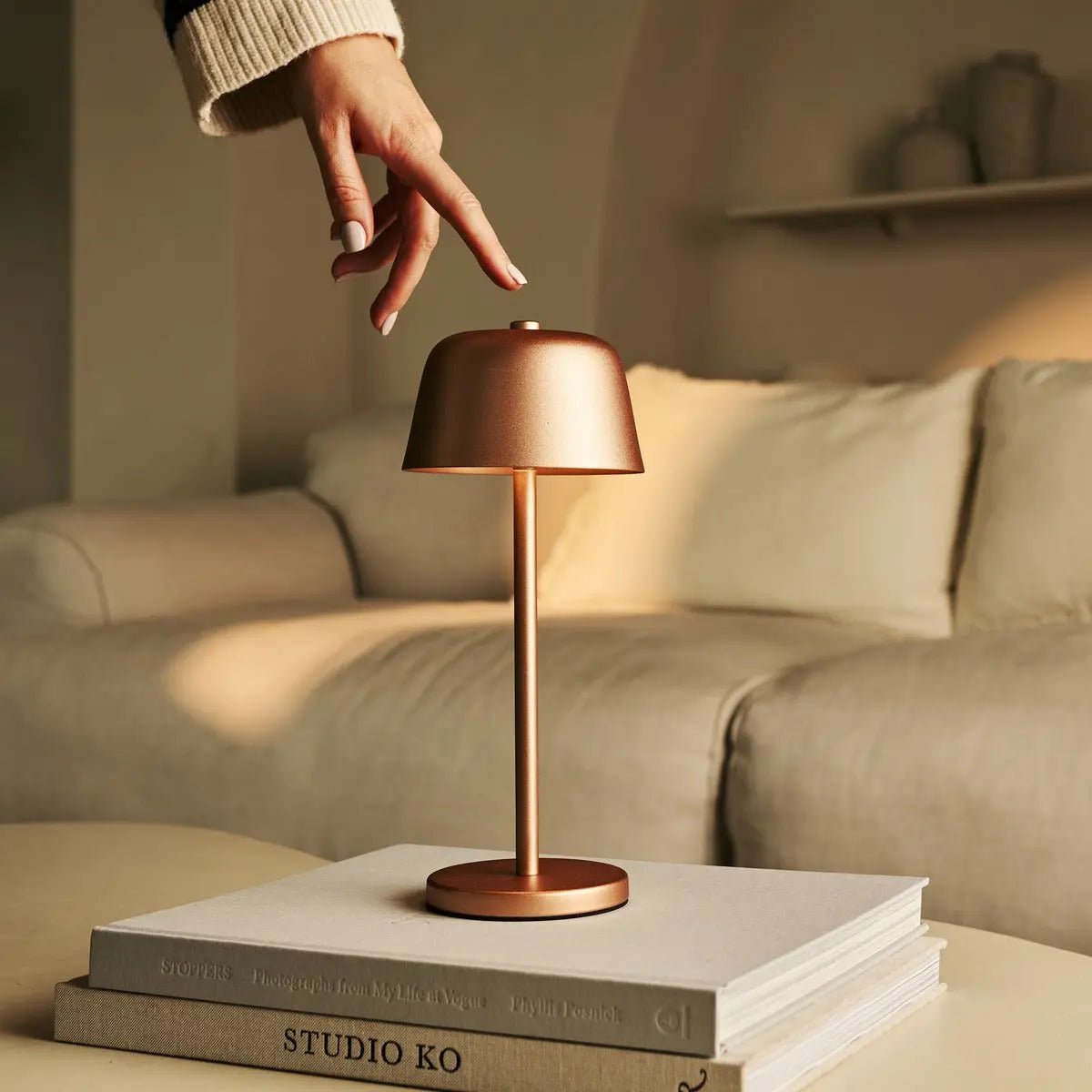 Gros plan sur la main réglant l'intensité lumineuse de la lampe cuivre.