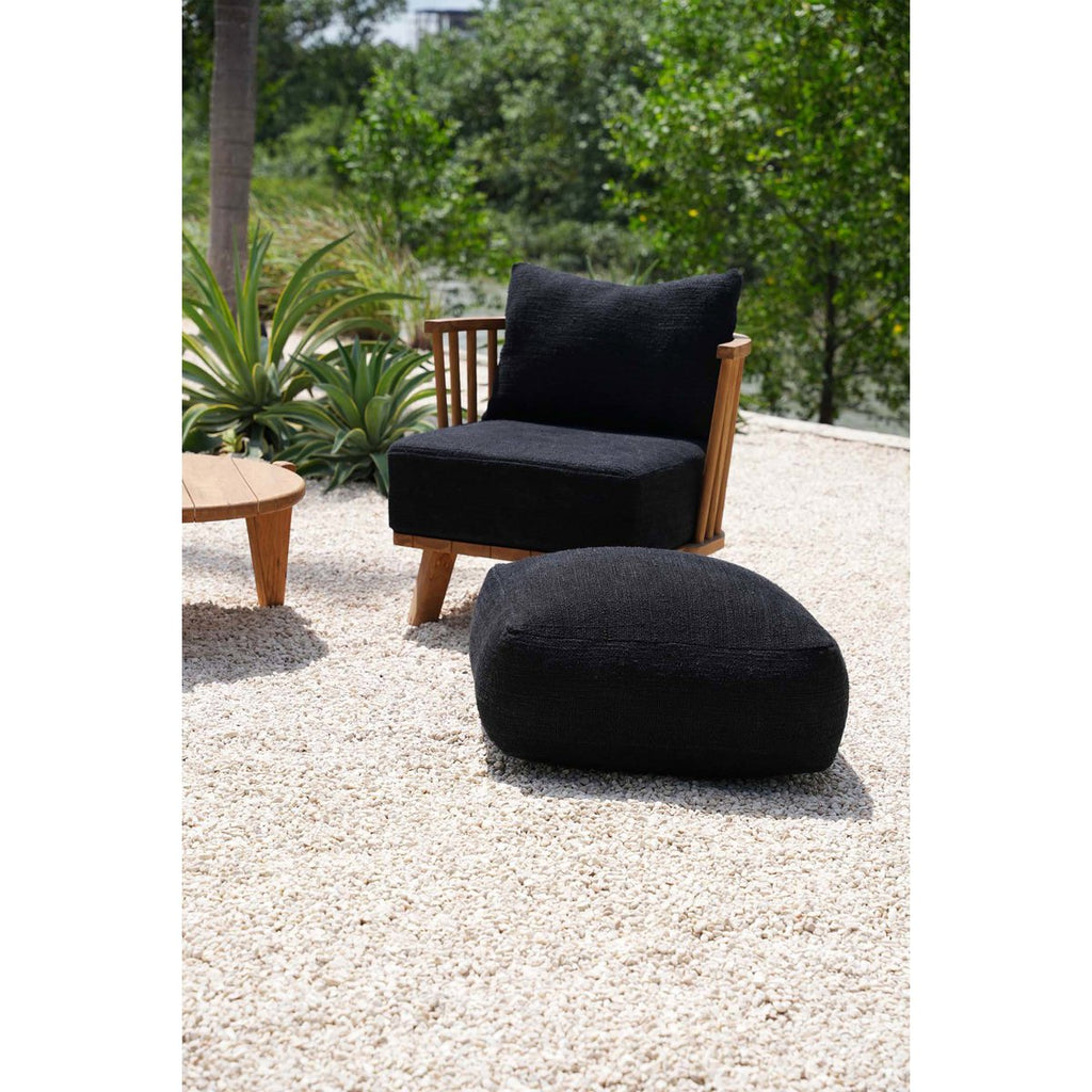 Mise en scène du pouf noir moelleux utilisé comme assise relaxante en extérieur.