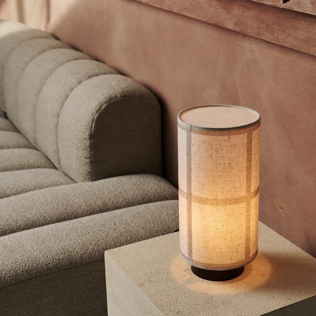 Lampe à poser Japandi diffusant une lumière douce, avec son abat-jour en lin texturé et son socle en bois.