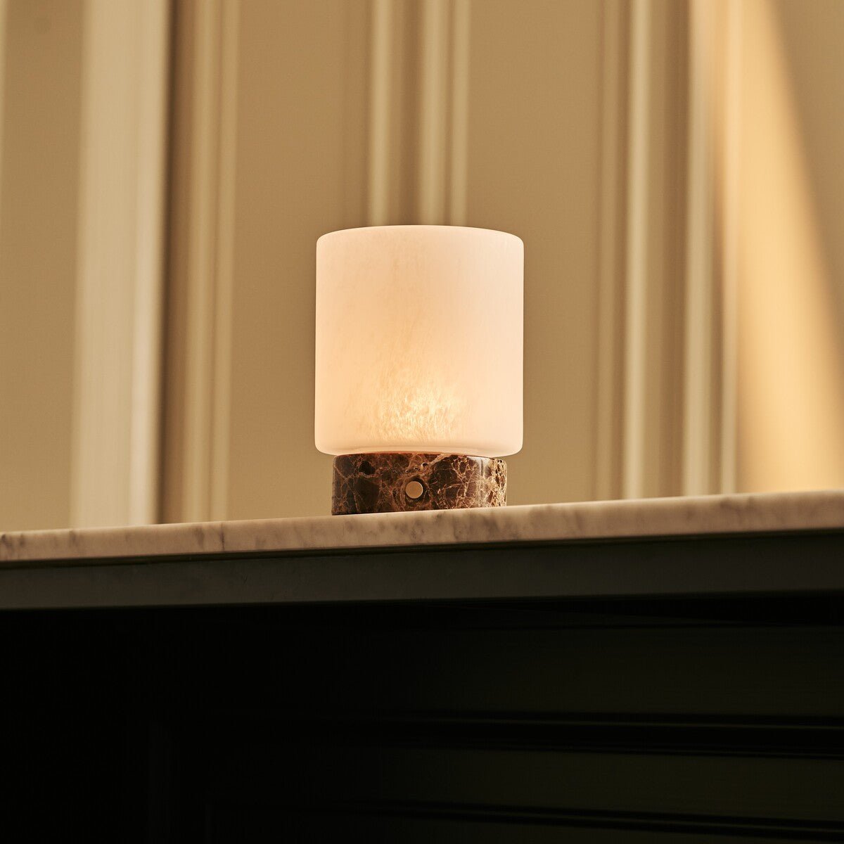 Ambiance chaleureuse avec la lampe nomade allumée en mode lumière douce.