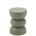 La table d'appoint en métal vert utilisée de manière élégante dans un salon chaleureux et lumineux.