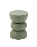 La table d'appoint en métal vert utilisée de manière élégante dans un salon chaleureux et lumineux.
