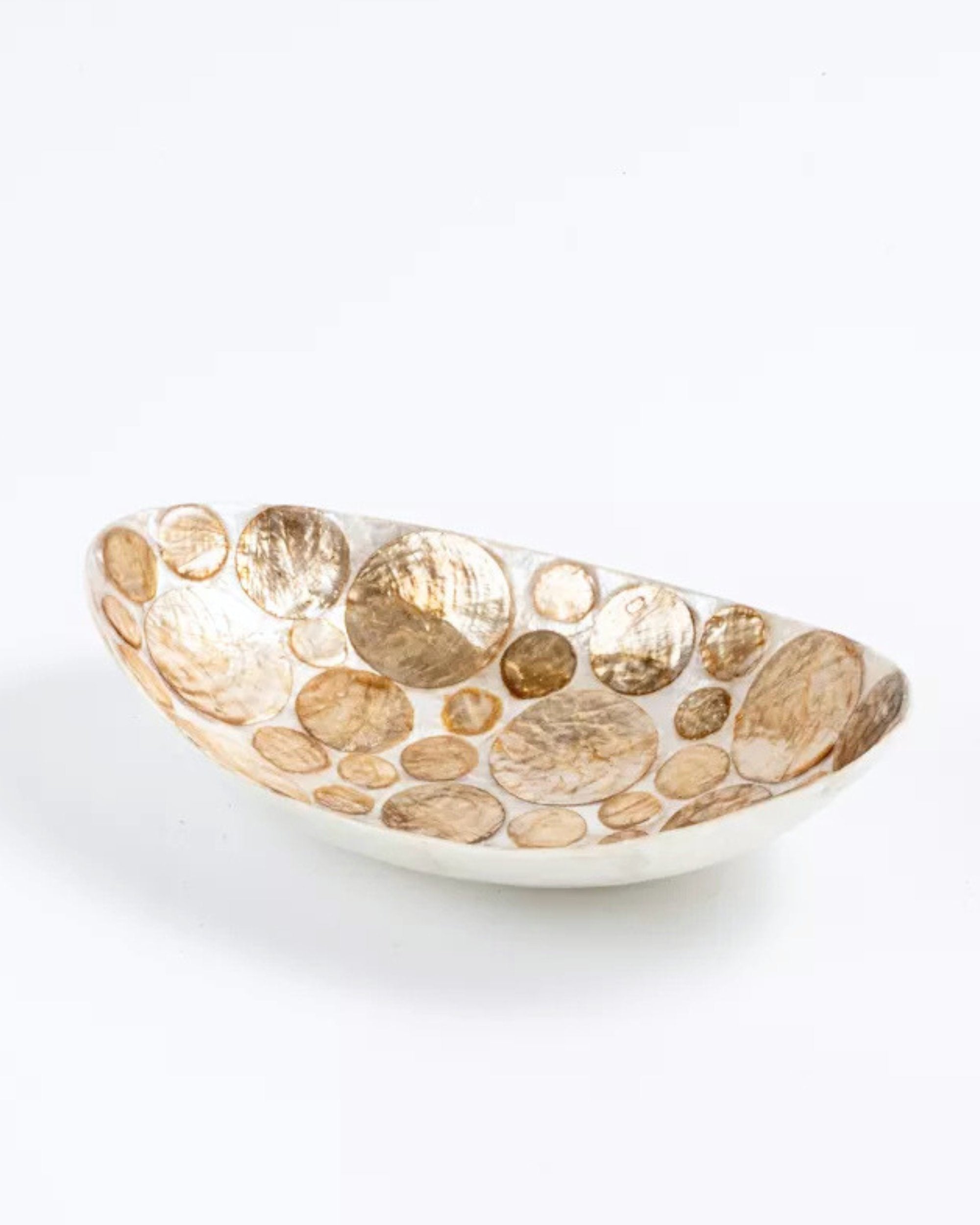 Une vue d'ensemble claire et nette de la coupelle ovale décorative façonnée à la main, posée sur un fond blanc pur. L'intérieur bicolore présente un motif complexe et lumineux de disques de nacre de Capiz naturelle (crème et doré) incrustés dans une résine blanche polie.