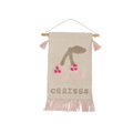 Tenture murale décorative en tissu tufté écru avec motif cerise rose fuchsia et taupe, inscription CERISES, pompons roses aux extrémités de la baguette bois et franges roses en bas, fond blanc, style bohème poétique pour chambre enfant