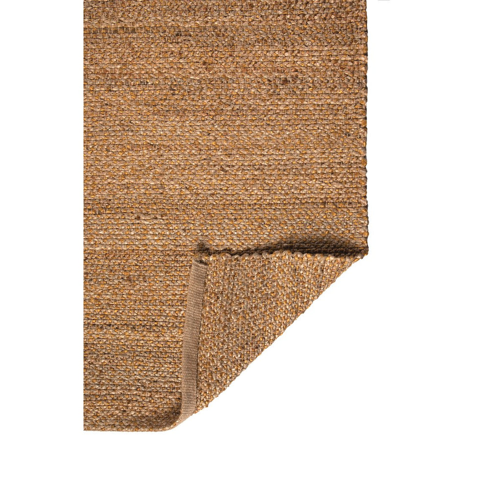 Détail du coin plié du tapis Elliot montrant l'épaisseur et la finition du tissage jute et coton.