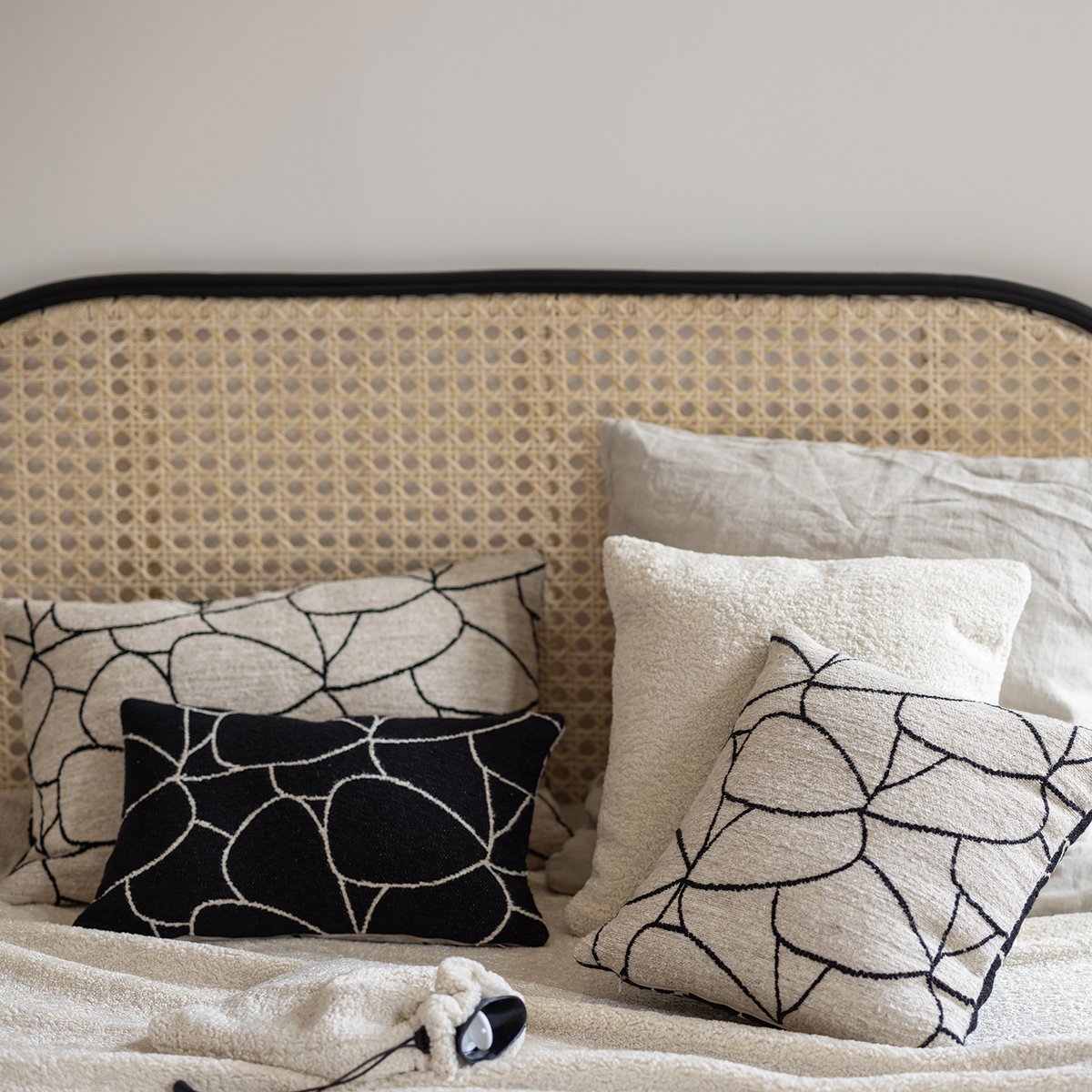 Décoration chambre tête de lit avec coussin lombaire graphique noir et blanc sur draps en lin