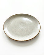 Vue détaillée de l'assiette Sienne montrant la texture irrégulière de l'émail et les bords légèrement relevés.