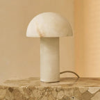 Lampe design ronde en pierre naturelle sur une table en travertin.