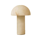 Lampe design ronde en pierre naturelle sur une table en travertin.