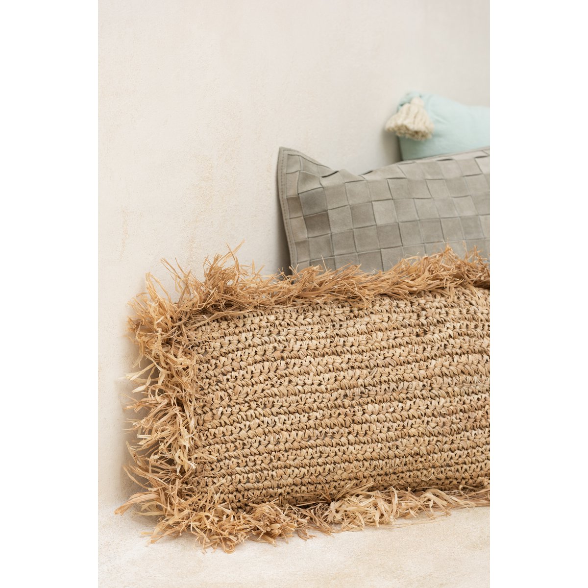 Vue d'ensemble du coussin posé délicatement, soulignant son allure chic et intemporelle.