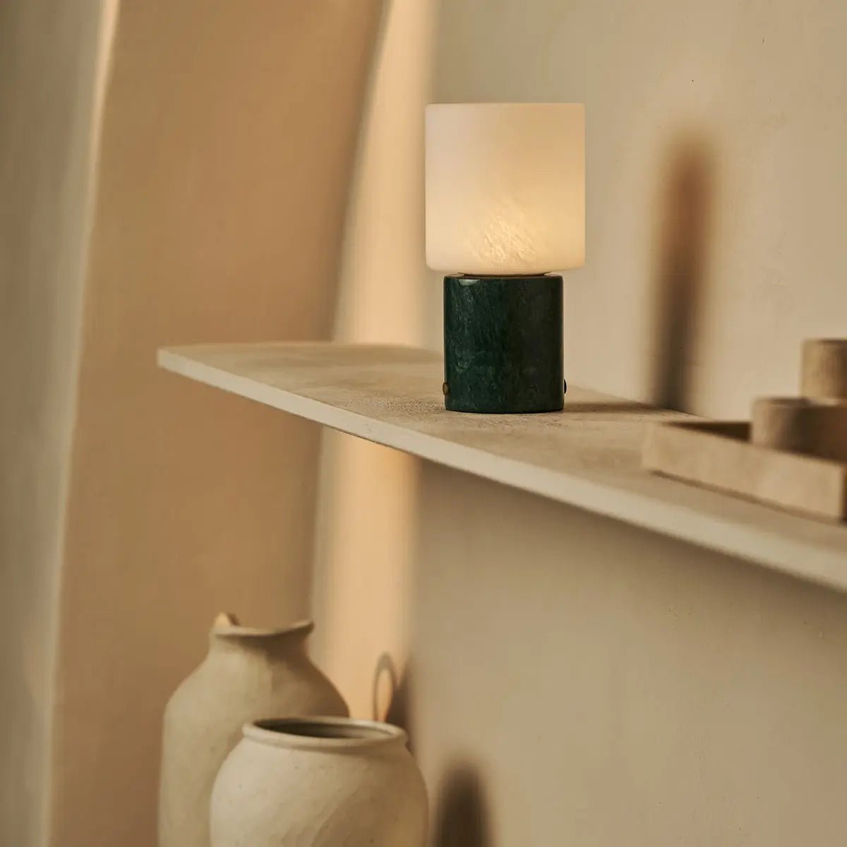 Lampe portable allumée posée sur une étagère.