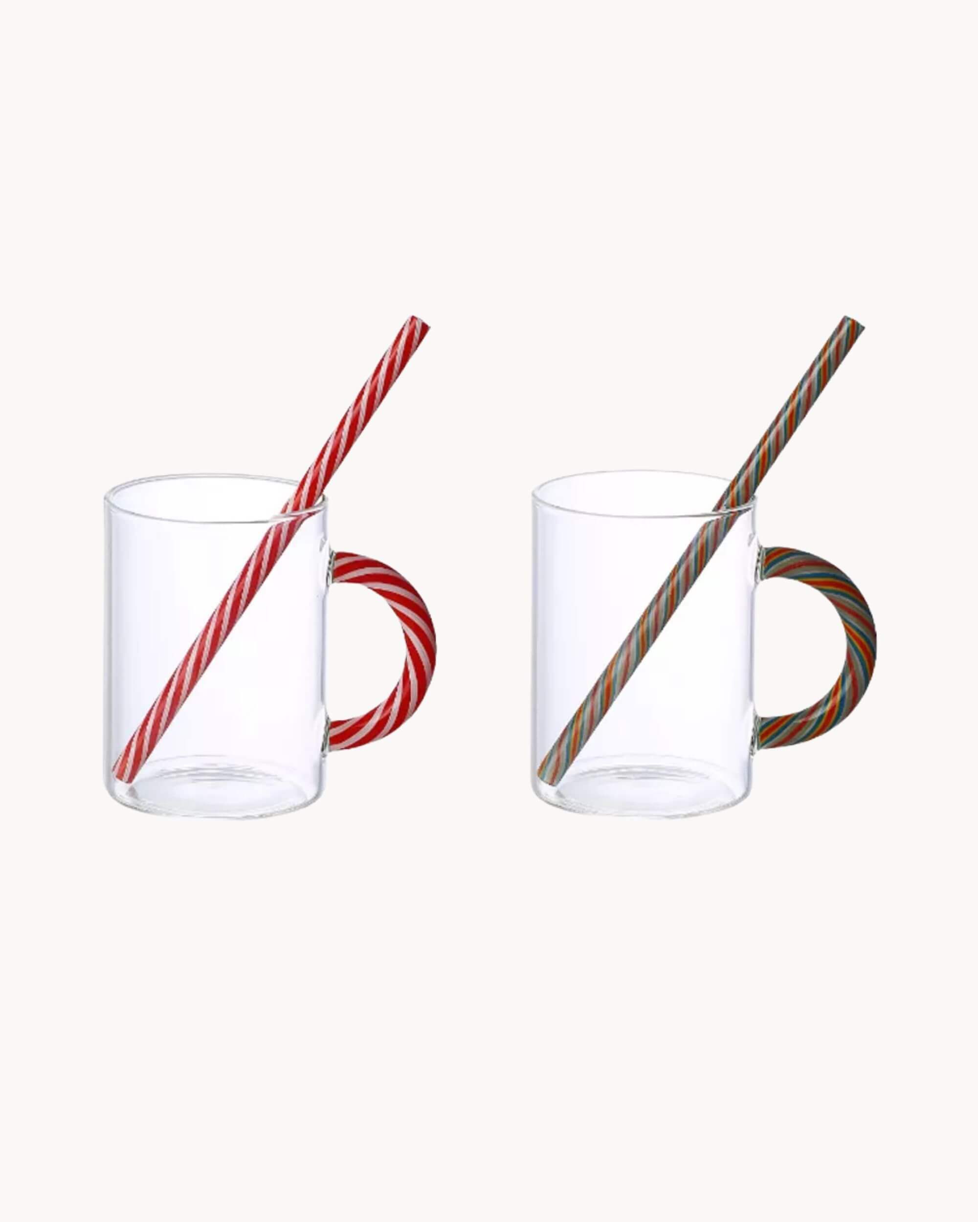 Lot de deux tasses en verre soufflé CANDY CANE avec anse rayée rouge et verte sur fond blanc.
