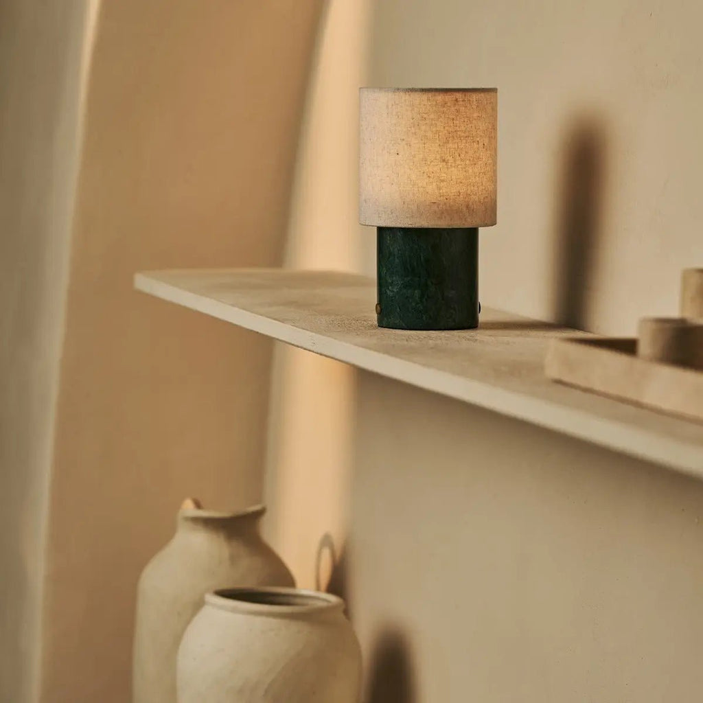 Lampe sans fil en marbre vert Onoda sur une étagère en bois minimaliste.