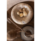 Vue de dessus de la coupe en pierre beige utilisée comme centre de table avec décoration séchée
