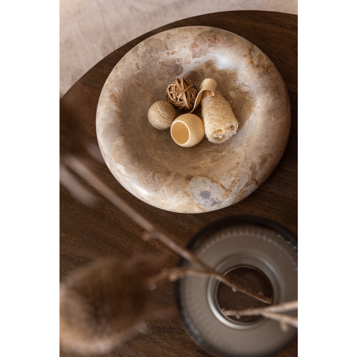 Vue de dessus de la coupe en pierre beige utilisée comme centre de table avec décoration séchée