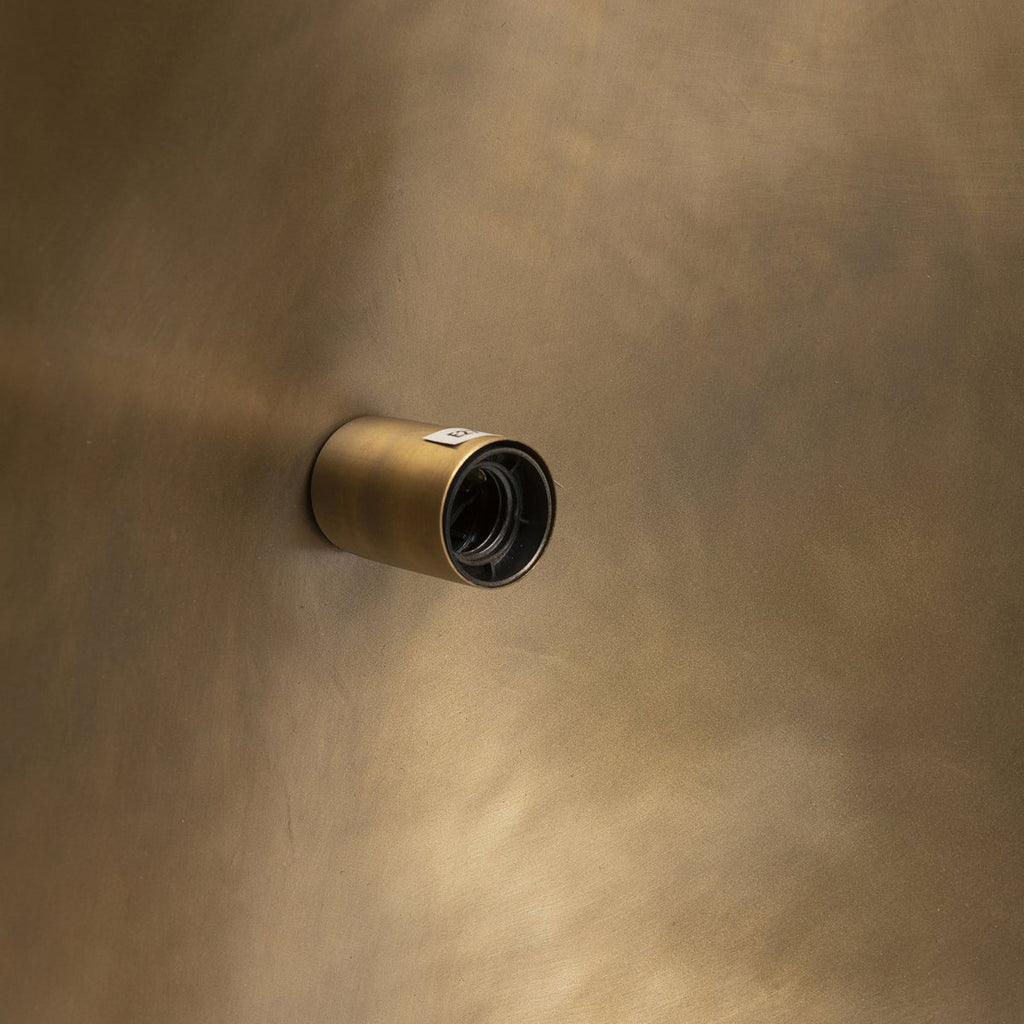 Vue intérieure de l'abat-jour doré projetant une lumière ciblée et chaleureuse.