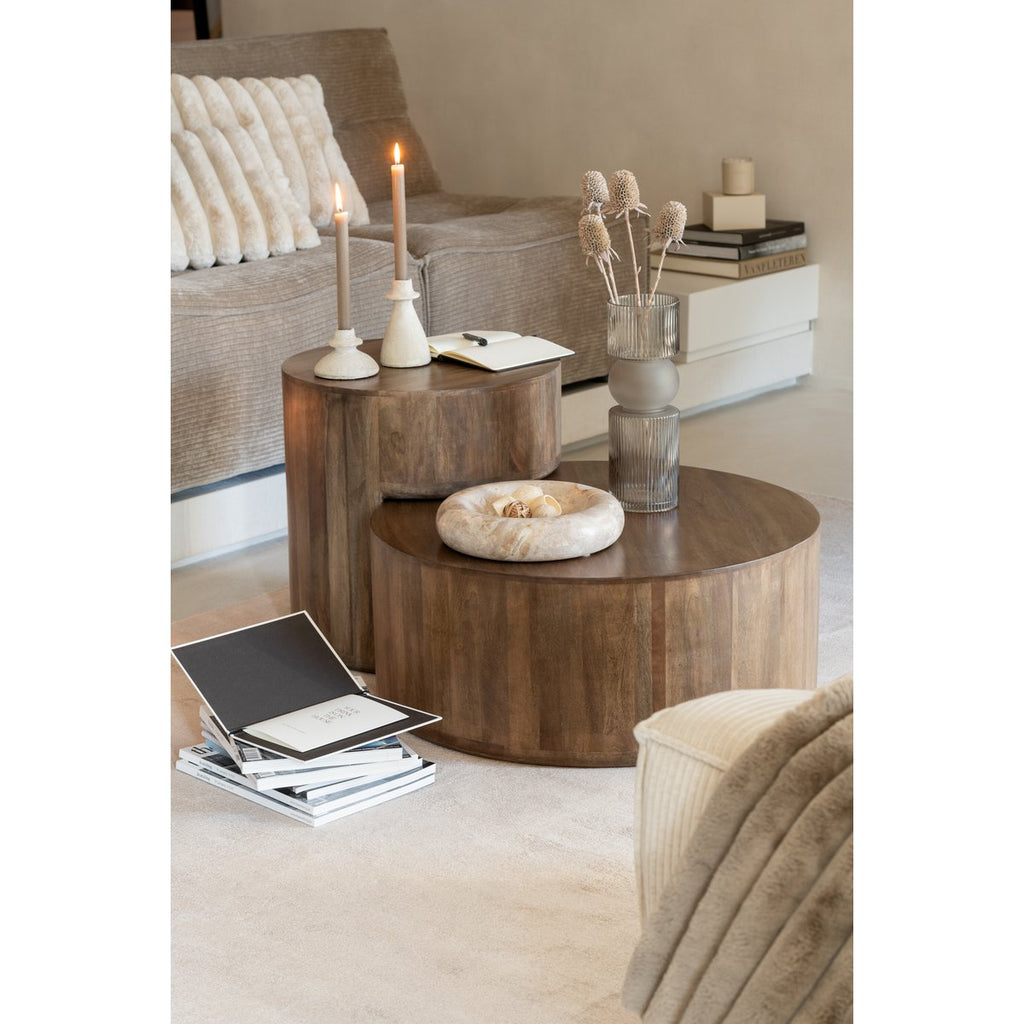 Coupe en pierre naturelle posée sur des tables basses gigognes en bois dans un salon moderne