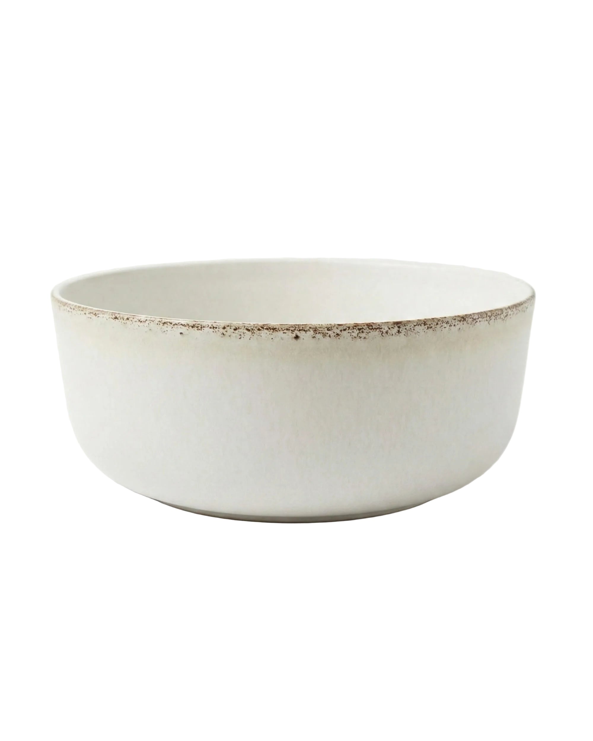 Gros plan sur la texture minérale du saladier Alba montrant son émail blanc cassé et son bord irrégulier.