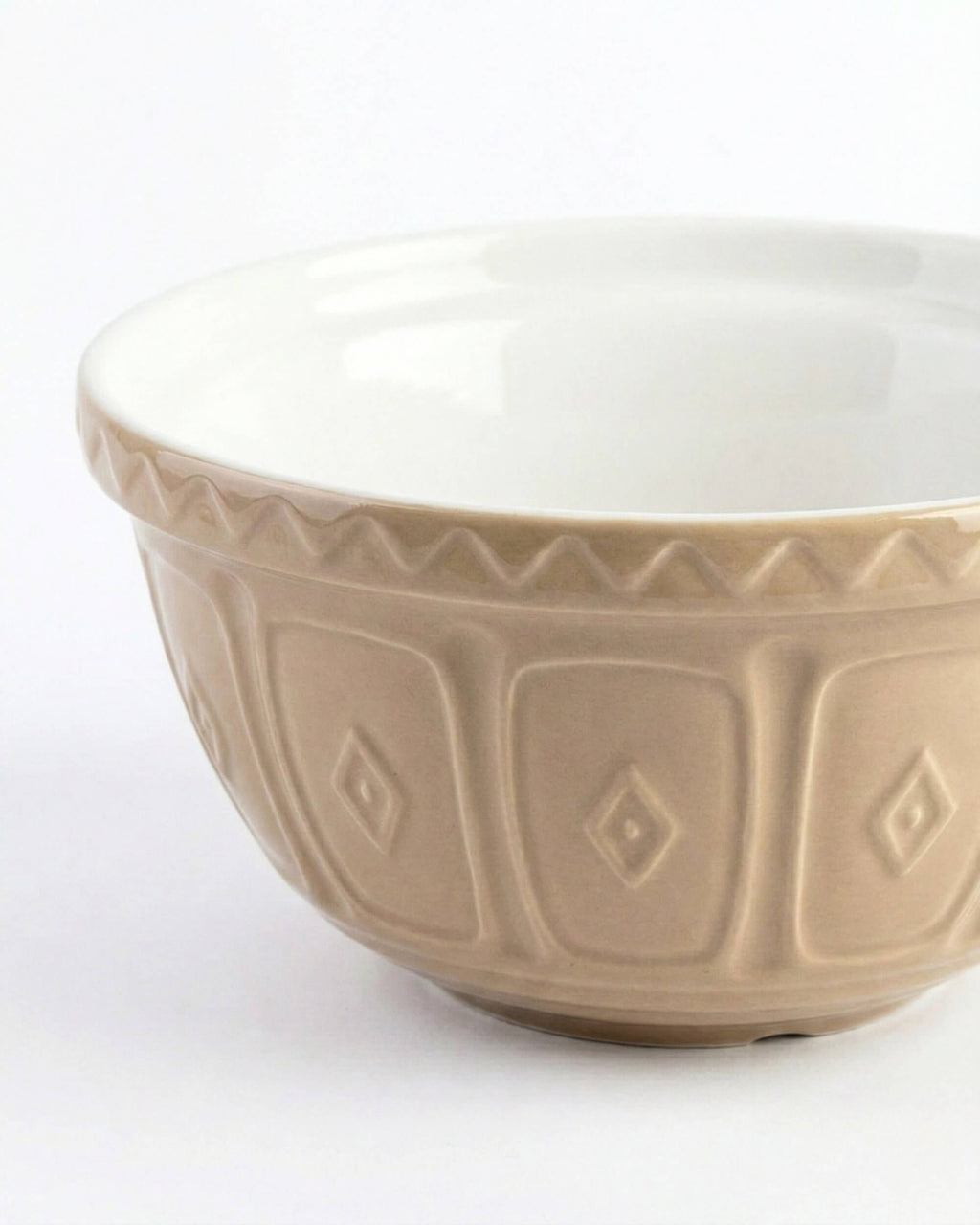 Gros plan sur les motifs en relief du saladier Livia et sa finition brillante bicolore beige et blanc