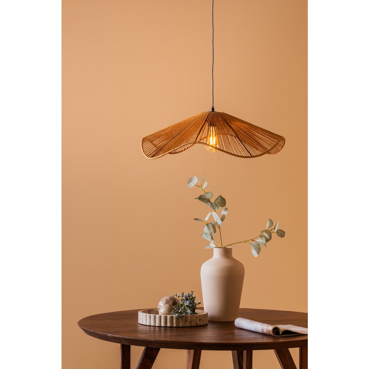 Mise en scène de la suspension naturelle allumée projetant une lueur chaleureuse au-dessus d'une petite table.