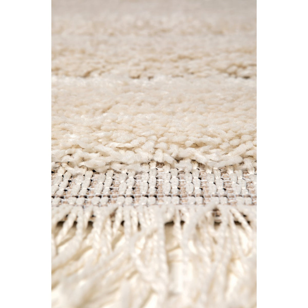 Zoom sur le tissage polypropylène aspect laine et les finitions frangées du tapis Solan.