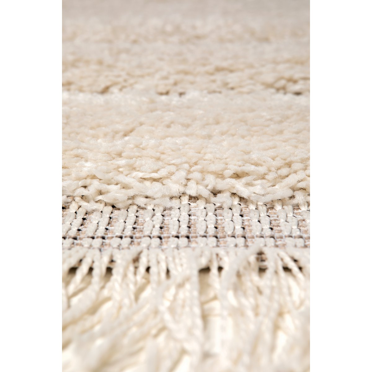 Zoom sur le tissage polypropylène aspect laine et les finitions frangées du tapis Solan.