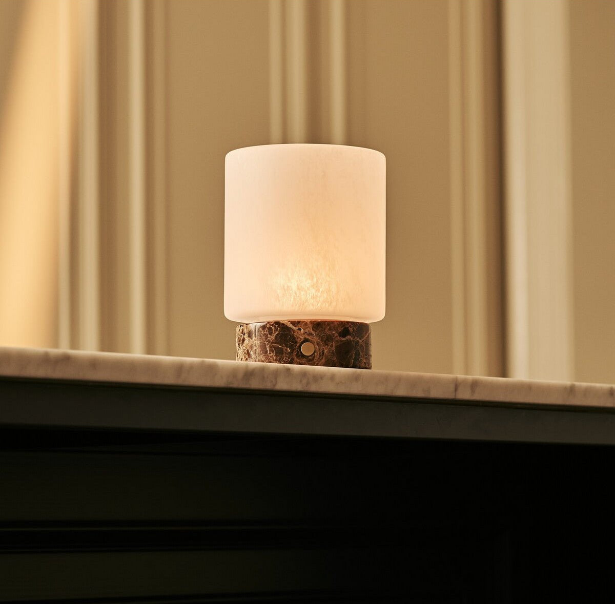 Ambiance chaleureuse avec la lampe nomade allumée en mode lumière douce.