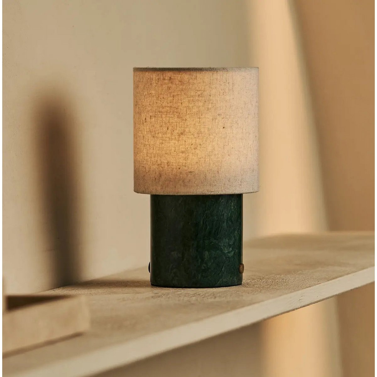 Lampe d'ambiance Onoda Green sur étagère murale, décoration intérieure épurée.