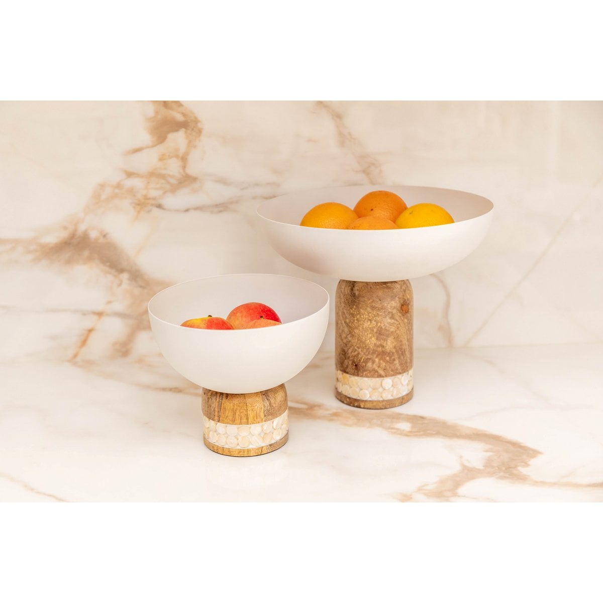 Mise en scène de la coupe sur pied et de son petit modèle assorti sur une table en marbre.