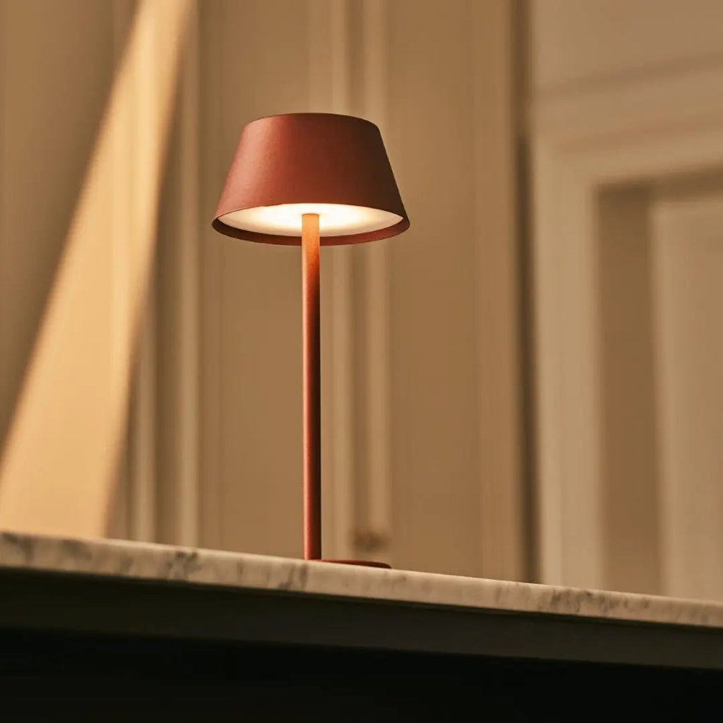 Lampe design minimaliste sur un comptoir de bar sombre.