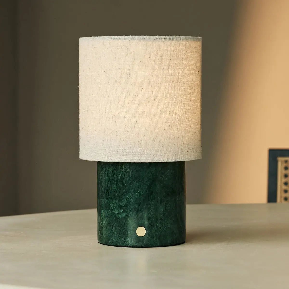 Lampe design portable Onoda marbre vert et abat-jour lin sur table claire.