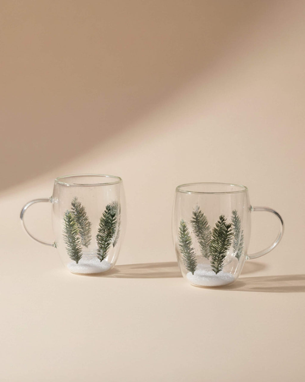 Lot de deux mugs double paroi décor sapin sur fond beige, vue produit.
